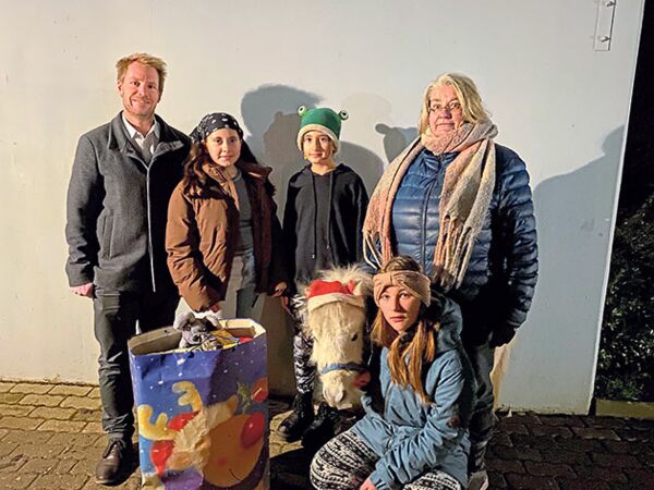Anette Bergmann (re.) verteilte zusammen mit ihrem „Weihnachts“-Ponys Daisy Geschenke in der Kindersiedlung Stipsdorf. Darüber freuten sich die Kinder und Bereichsleiter Tim Wienke.Foto: hfr