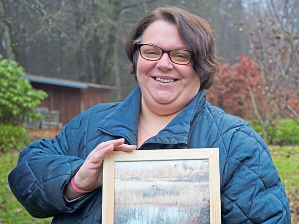 Janine Schocke zeigt ein gerahmtes Bild, das sie vom Twiete-Teich gemacht hat.Foto: by